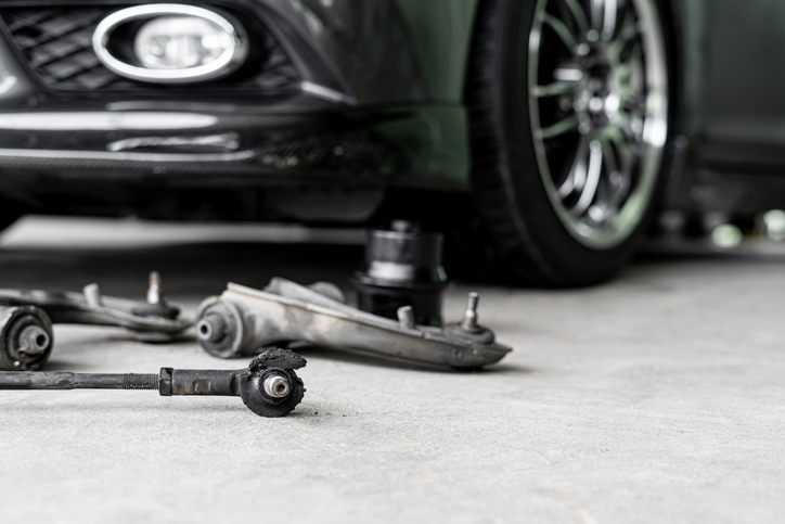 Fahrwerk und Querlenker auf Werkstattboden